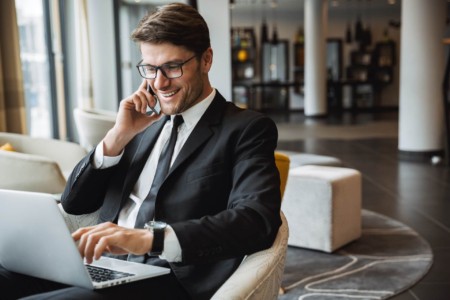Homem com Celular e Notebook